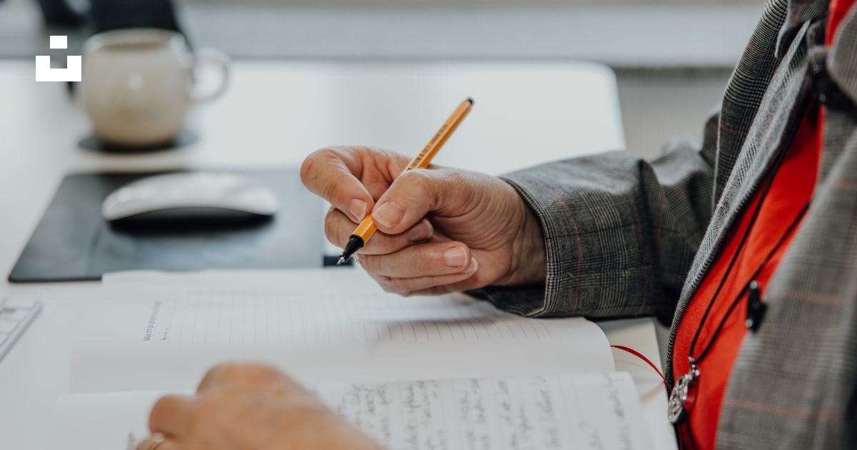 A hand signing a document at a desk
